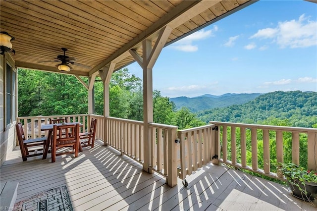 883 Wagon Ridge Ln, Ferguson, NC 28624 - deck with a mountain view, ceiling fan, outdoor dining space, and a view of trees
