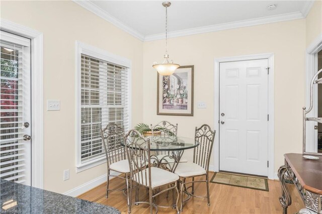 dining area with ornamental molding and light wood-type flooring