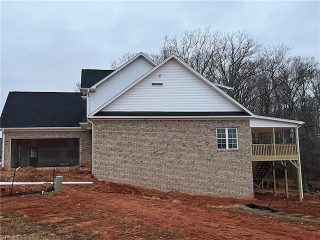 view of side of home with a garage and a sunroom