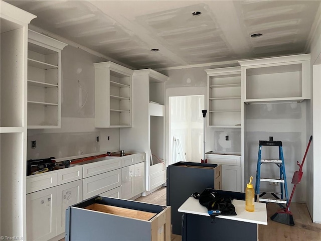 kitchen featuring white cabinets, light wood-style floors, open shelves, and a center island