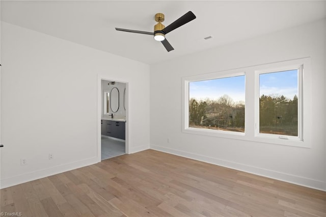 unfurnished bedroom with ceiling fan, ensuite bath, and light hardwood / wood-style flooring