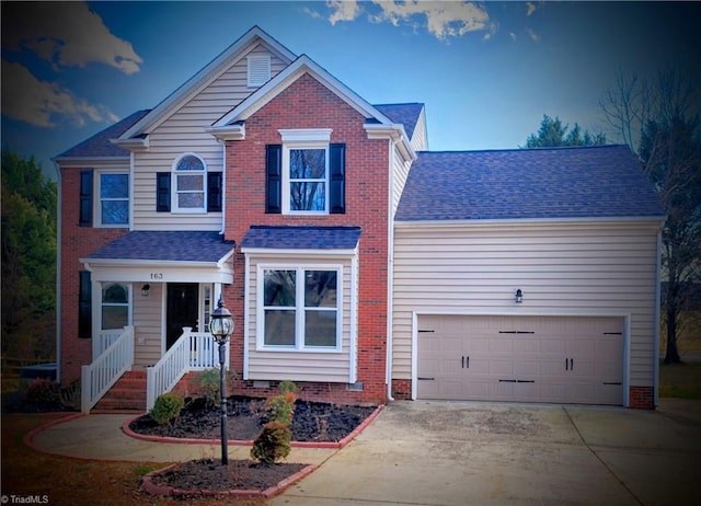 traditional-style home featuring driveway, an attached garage, and roof with shingles