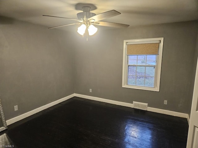 spare room featuring dark hardwood / wood-style flooring and ceiling fan