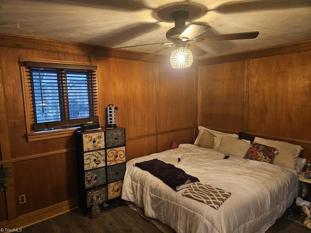 bedroom with wood walls, ceiling fan, and wood-type flooring