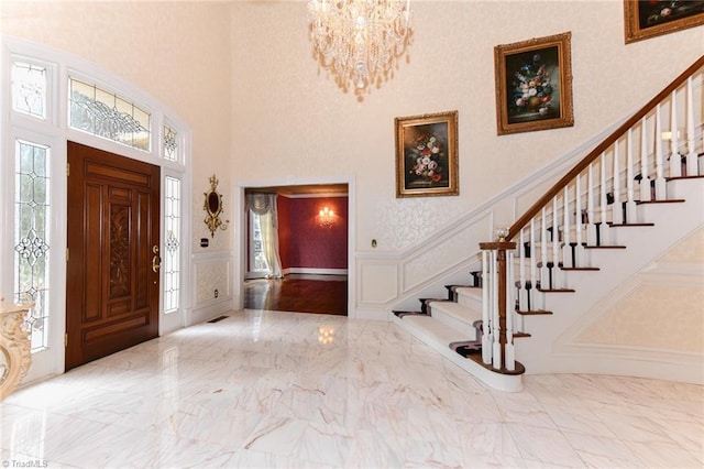 entryway featuring a towering ceiling and a chandelier