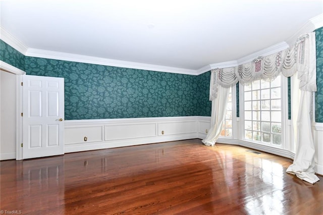 empty room featuring hardwood / wood-style flooring and crown molding