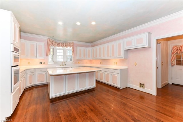 kitchen featuring dark hardwood / wood-style floors, a center island, and white cabinets