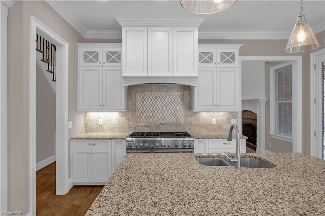 kitchen with crown molding, a sink, white cabinets, and double oven range