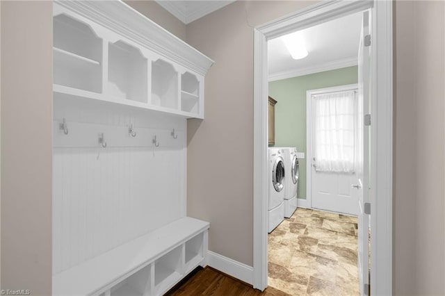 mudroom featuring baseboards, washer and clothes dryer, and crown molding