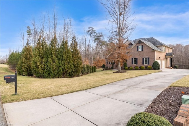 view of front of property with a front yard, concrete driveway, and brick siding