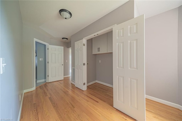 unfurnished bedroom with light wood-type flooring and a closet