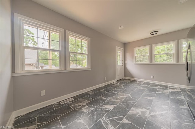 unfurnished room featuring a healthy amount of sunlight