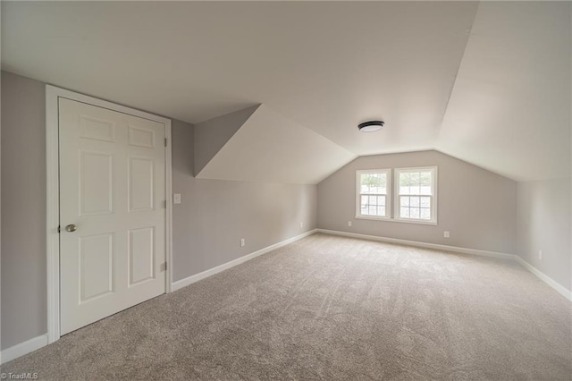 bonus room featuring light colored carpet and vaulted ceiling