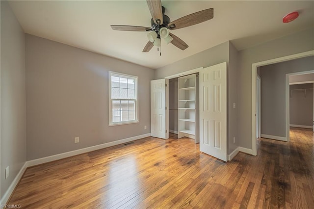 unfurnished bedroom with hardwood / wood-style floors, a closet, and ceiling fan