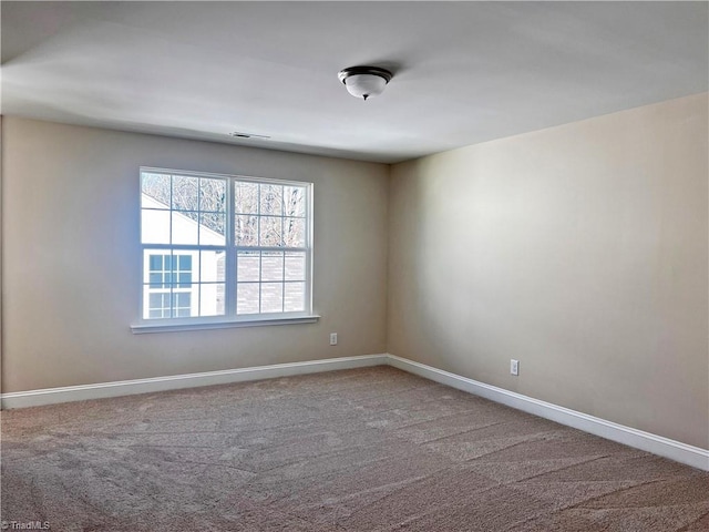 carpeted spare room featuring visible vents and baseboards