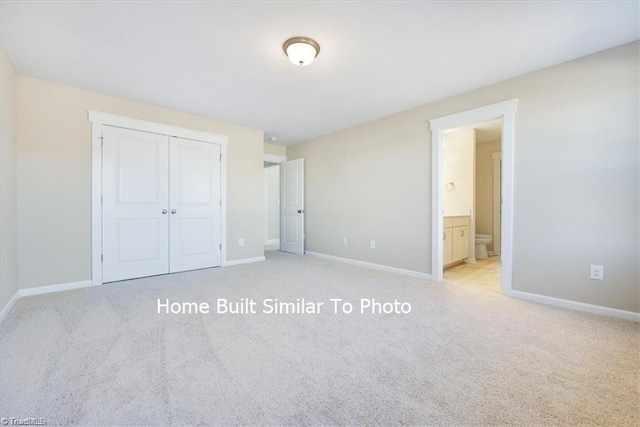 unfurnished bedroom with light carpet, baseboards, and a closet