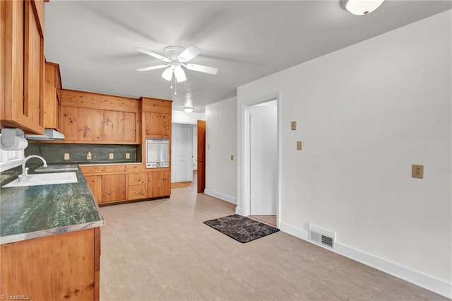 kitchen with ceiling fan, sink, white fridge, tasteful backsplash, and light hardwood / wood-style floors