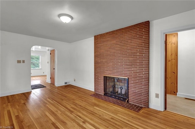 unfurnished living room with light wood-type flooring and a fireplace