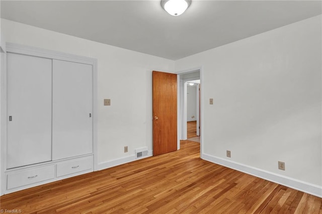 unfurnished bedroom with a closet and hardwood / wood-style flooring