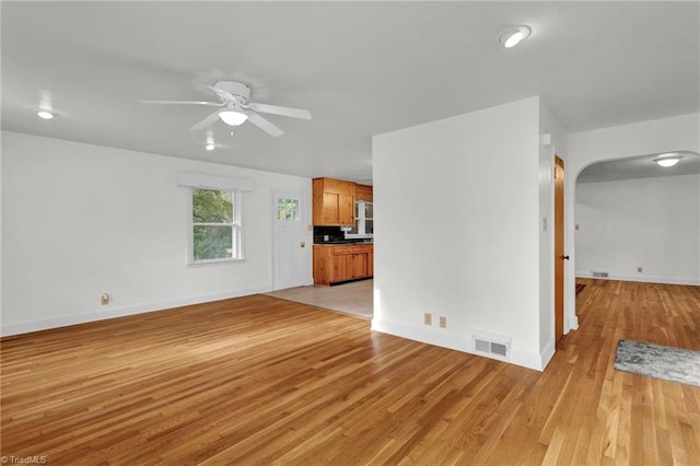 unfurnished living room featuring ceiling fan and light wood-type flooring