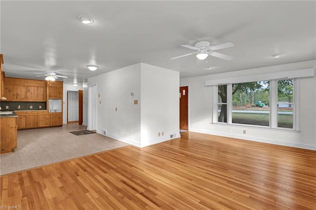 unfurnished living room featuring light hardwood / wood-style floors and ceiling fan