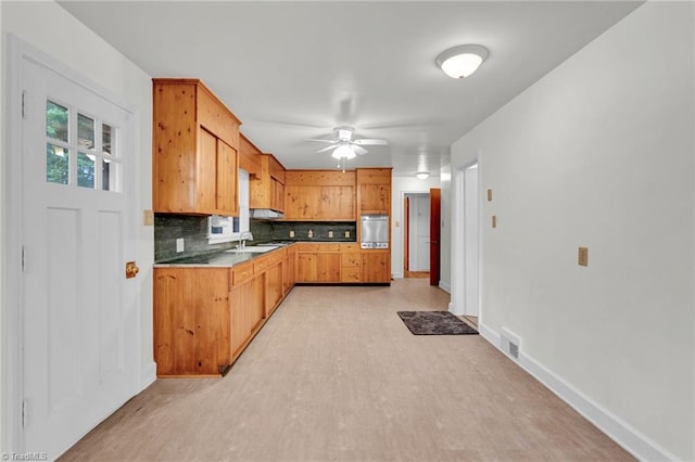 kitchen with light hardwood / wood-style floors, sink, backsplash, ceiling fan, and stainless steel fridge