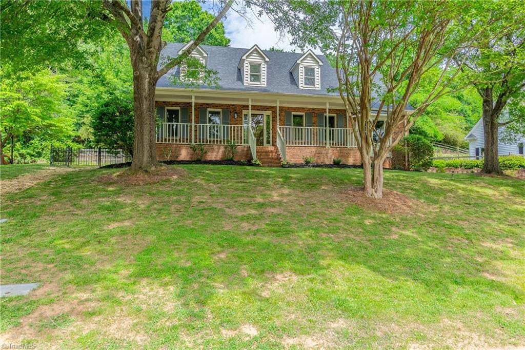 3557 Summerfield Ln, Winston-Salem, NC 27106 - new england style home featuring brick siding and covered porch