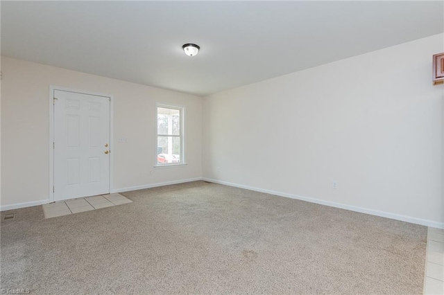 spare room with light carpet and baseboards