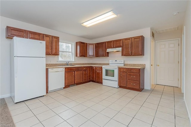 kitchen featuring visible vents, brown cabinets, under cabinet range hood, white appliances, and light countertops