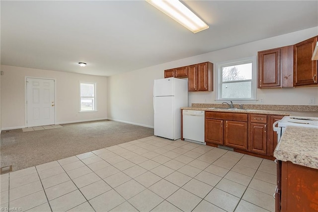 kitchen with light carpet, a sink, open floor plan, white appliances, and light countertops