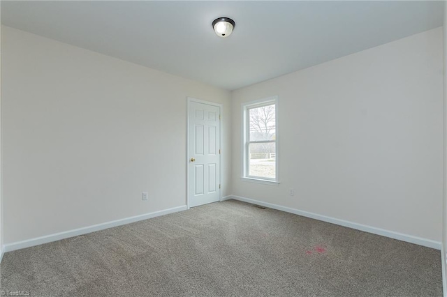 unfurnished room with baseboards and carpet floors