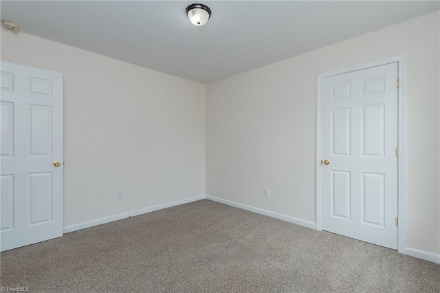 empty room featuring baseboards and carpet floors