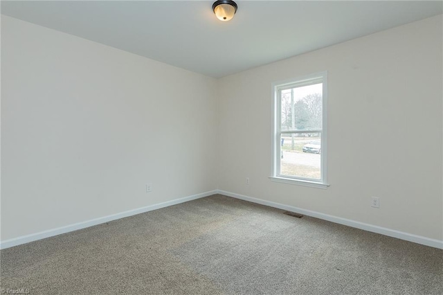 spare room featuring visible vents, baseboards, and carpet