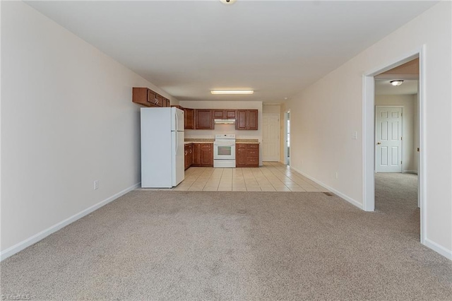 kitchen featuring light carpet, under cabinet range hood, white appliances, light countertops, and baseboards