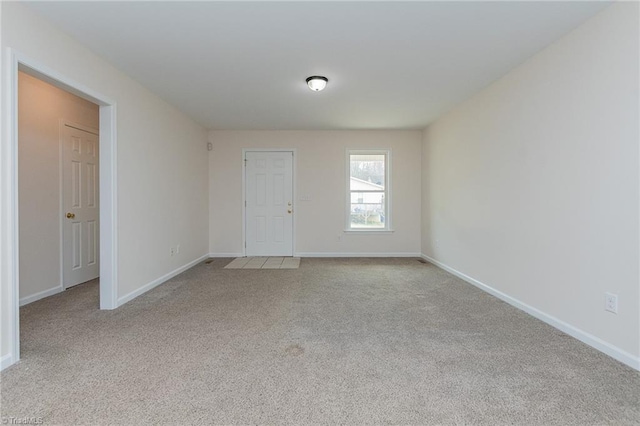 spare room with baseboards and carpet flooring