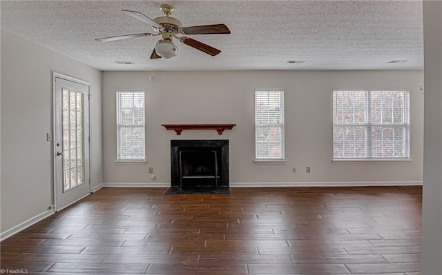 unfurnished living room with ceiling fan, dark hardwood / wood-style flooring, and a textured ceiling