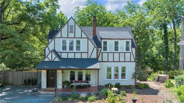1501 Wiltshire St, High Point, NC 27265 - tudor home featuring covered porch, stucco siding, a chimney, and a shingled roof