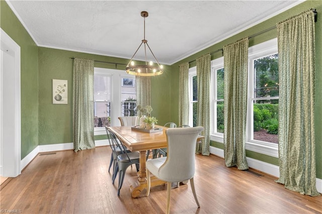 1501 Wiltshire St, High Point, NC 27265 - dining space featuring a chandelier, crown molding, wood finished floors, baseboards, and plenty of natural light