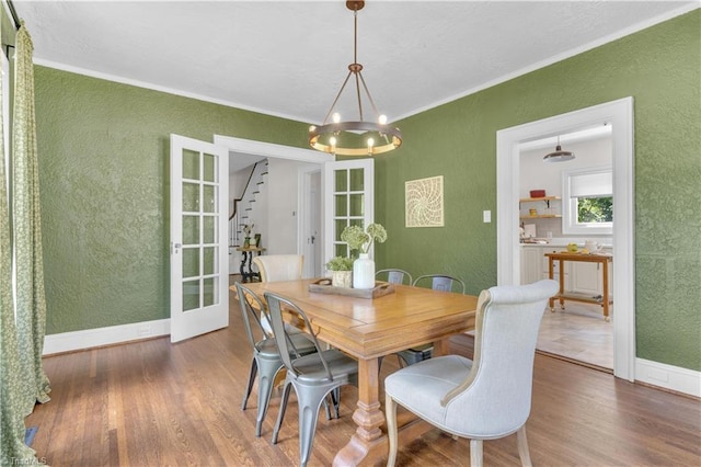 1501 Wiltshire St, High Point, NC 27265 - dining room with a textured wall, wood finished floors, crown molding, a chandelier, and baseboards