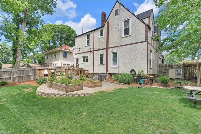1501 Wiltshire St, High Point, NC 27265 - rear view of property with a vegetable garden, stucco siding, and a chimney