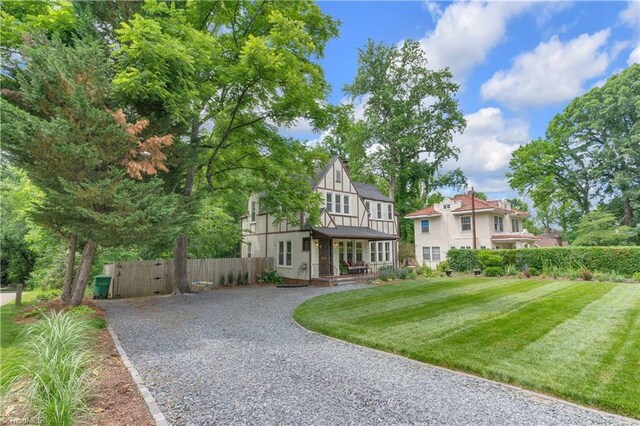 1501 Wiltshire St, High Point, NC 27265 - tudor house featuring gravel driveway, a porch, and a gate