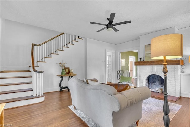 1501 Wiltshire St, High Point, NC 27265 - living area with a textured ceiling, a ceiling fan, stairway, wood finished floors, and a fireplace