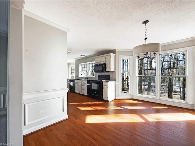 unfurnished living room featuring a notable chandelier, dark wood-type flooring, a textured ceiling, and sink