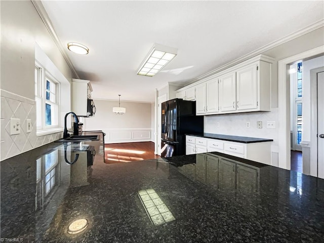 kitchen with white cabinets, dark stone counters, black appliances, and pendant lighting