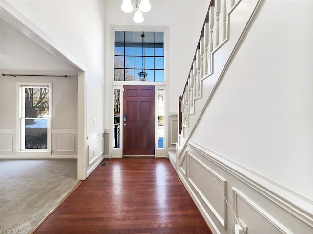 foyer entrance with dark wood-type flooring and an inviting chandelier