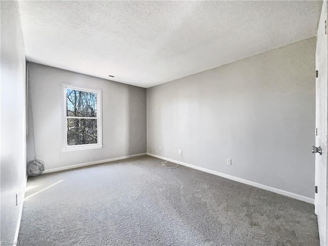 carpeted spare room featuring a textured ceiling