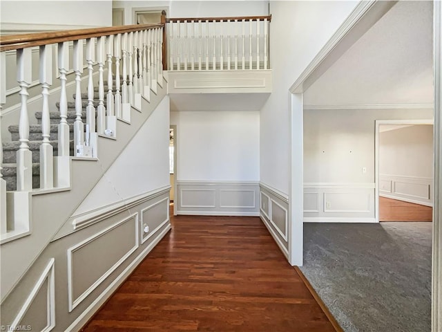 staircase with ornamental molding and wood-type flooring