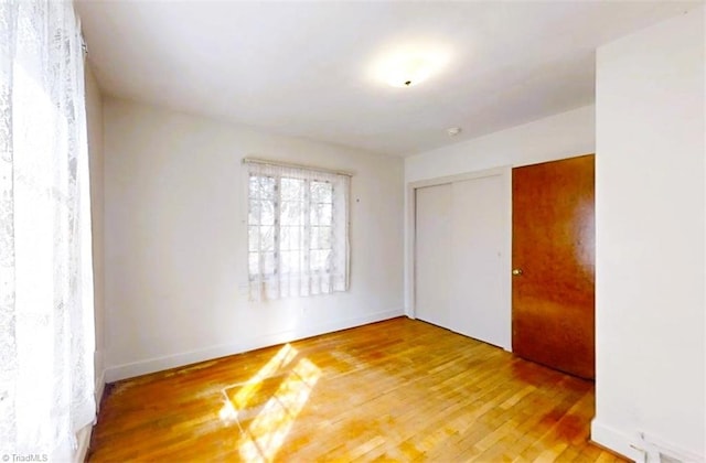 spare room featuring hardwood / wood-style flooring and baseboards