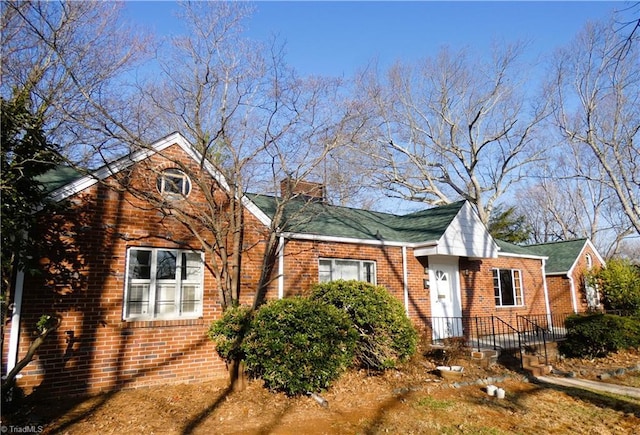 view of front of property with brick siding and a chimney