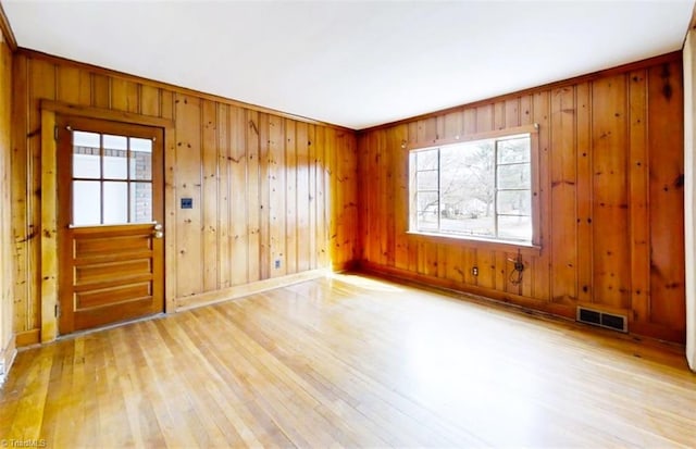 spare room featuring wood finished floors and visible vents